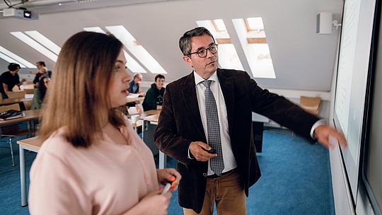 Dozent und Studentin an Tafel